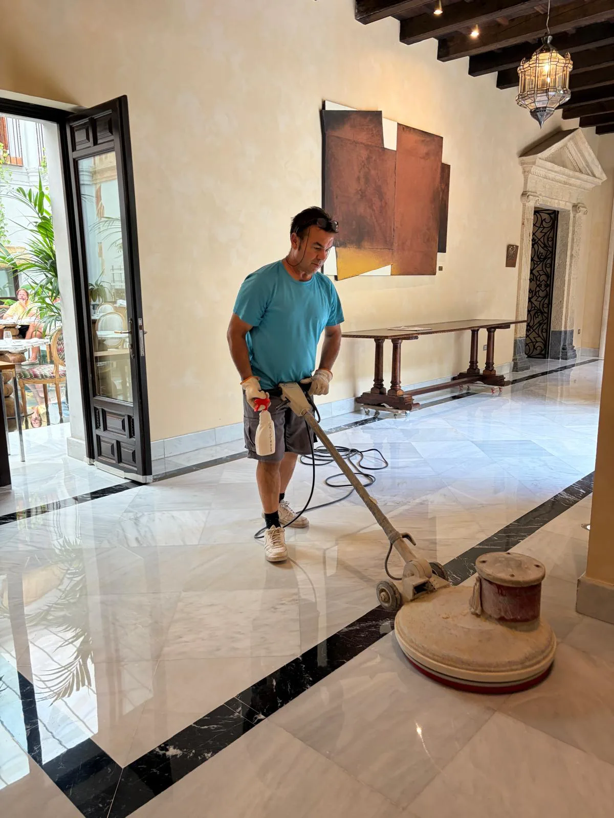 Cristalizado y vitrificado de un suelo de mármol blanco con cenefa negra en el hall de un hotel, con acabado brillo espejo — trabajo real de Pulimentos Jiménez